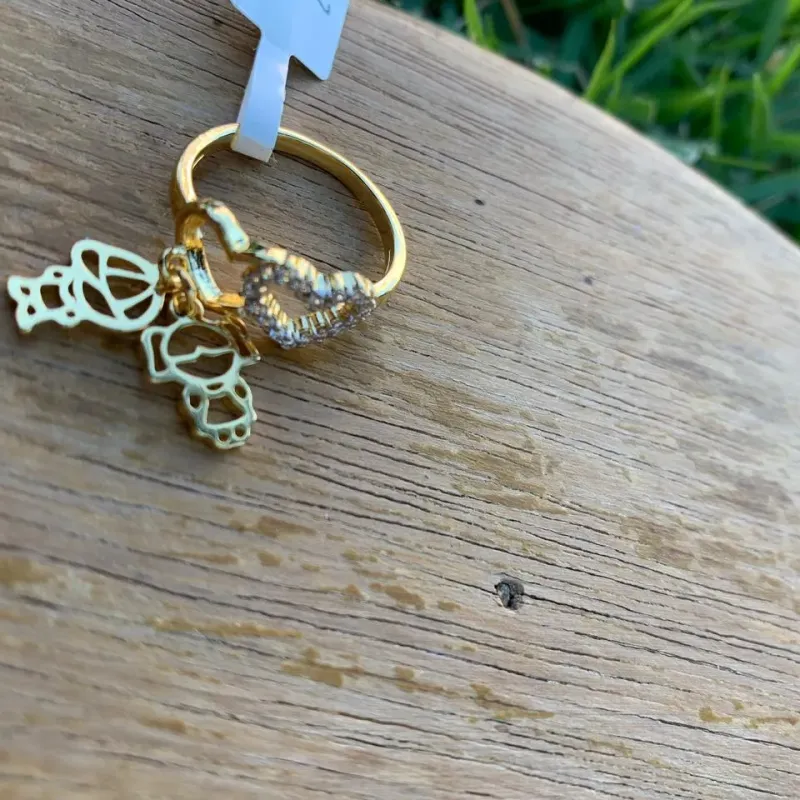 ANEL CORAÇÃO CRAVEJADO E LISO COM CASAL VAZADAS PENDURADO Nª21  - BANHADO A OURO 18K ANEL CORAÇÃO CRAVEJADO E LISO COM CASAL VAZADAS PENDURADO Nª21  - BANHADO A OURO 18K