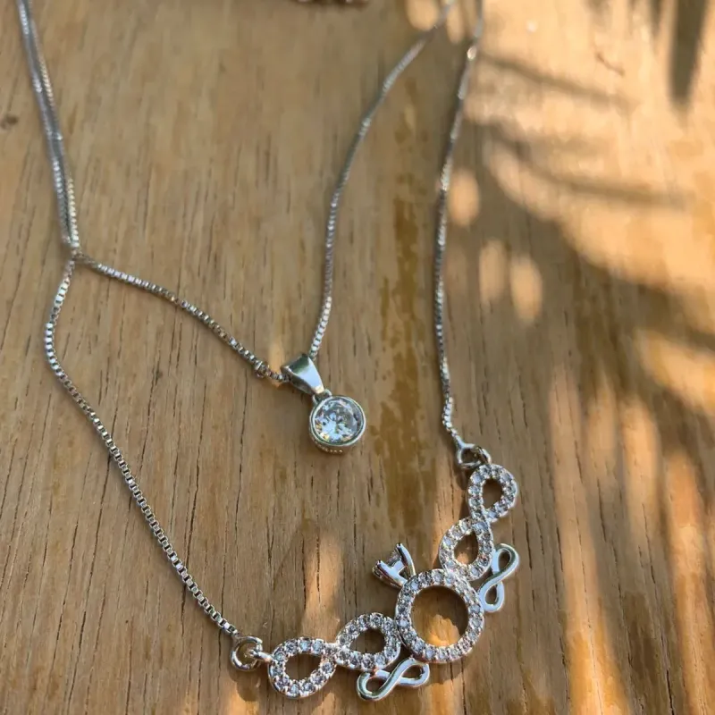 CORRENTE DUPLA ALIANÇA E SÍMBOLO INFINITO COM PONTO DE LUZ COM EXTENSOR- BANHADO A RÓDIO BRANCO CORRENTE DUPLA ALIANÇA E SÍMBOLO INFINITO COM PONTO DE LUZ COM EXTENSOR- BANHADO A RÓDIO BRANCO