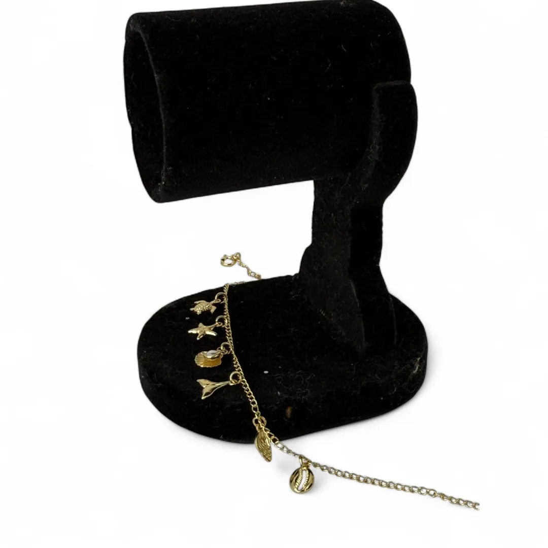 TORNOZELEIRA ELO GRUMET COM PENDURICALHO ESTRELA DO MAR, CONCHA, RABO DE BALEIA, TARTARUGA E PÉROLA COM EXTENSOR - BANHADO A OURO 18K