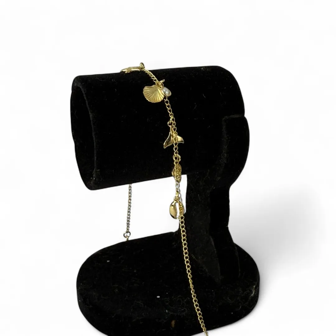 TORNOZELEIRA ELO GRUMET COM PENDURICALHO ESTRELA DO MAR, CONCHA, RABO DE BALEIA, TARTARUGA E PÉROLA COM EXTENSOR - BANHADO A OURO 18K