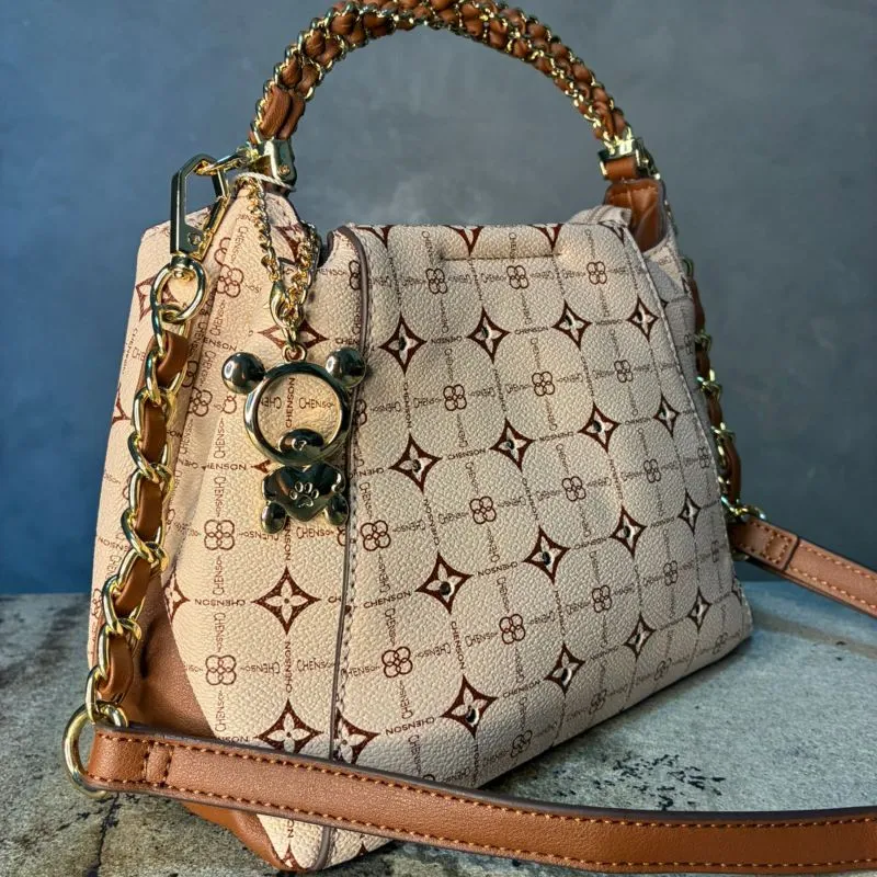 BOLSA TIPO SACO BEGE COM MONOGRAMA E ZIRCÔNIA ALÇA COM DETALHES EM METAL + ALÇA REMOVIVEL COM CORRENTE E CHAVEIRO URSINHO EM METAL CHENSON